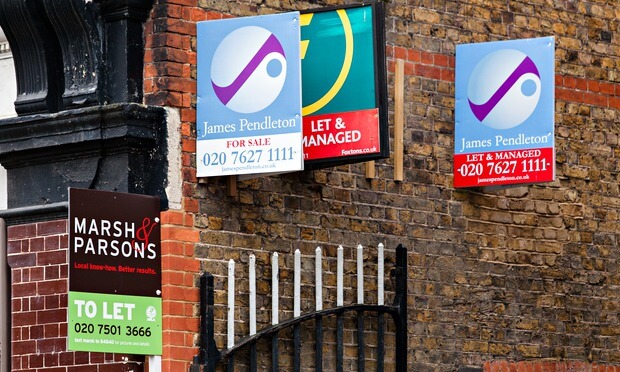 estate agents boards against house wall