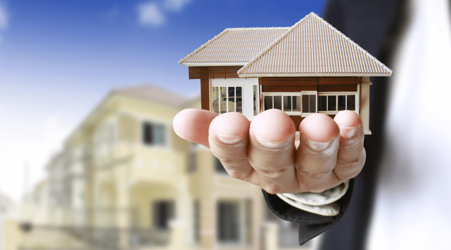 Hand holding a model house